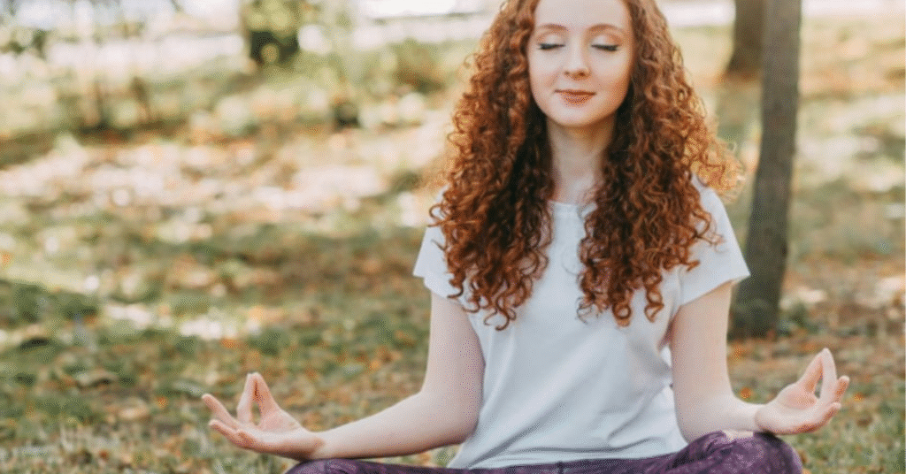 A women is sitting in a Yoga pose to celeberate the women's mental health month.